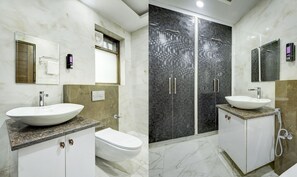 A modern bathroom with a large white sink, a toilet, and a walk-in shower with a glass door. - Itsy Hotels Vibe 2 (Noida)