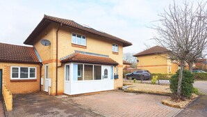 A two-story residential house with a tiled roof, a satellite dish, and a driveway leading to a garage. - Milton Keynes Close to Station 6 bed Free Parking (Milton Keynes)