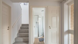 A staircase leading to a glass shower room, with a rug on the floor and a door on the right. - Milton Keynes Close to Station 6 bed Free Parking (Milton Keynes)