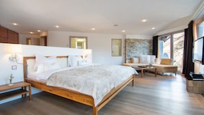 Un dormitorio moderno con una cama de madera, un sofá, una mesa de centro y una pared de acento de piedra.