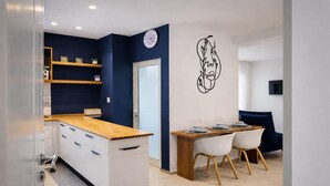 A modern kitchen with white cabinets, a wooden countertop, and a dining area with a table and chairs. - Lovely 1-bed Apartment in Lac1 Tunis (Tunis)