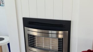 Una cocina moderna con horno de acero inoxidable integrado, muebles de cocina blancos y piso de madera.