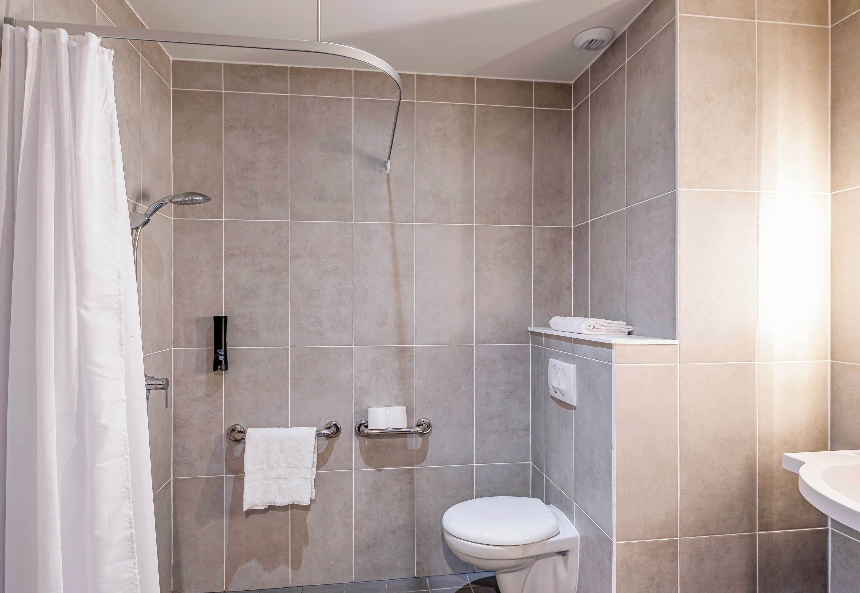Un baño moderno con ducha, inodoro y lavamanos.
