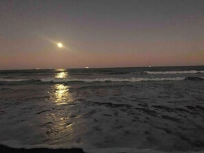 A beach at dusk with waves reflecting the moonlight. - Rocket Launches | 250 Steps to the Sand | King Bed! (Cocoa Beach)