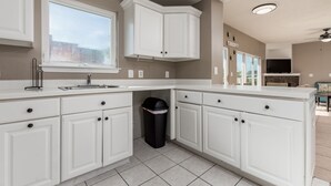 A modern kitchen with white cabinetry, a window, and a ceiling fan. - Princess Irene Unit 202 Oceanside 3BR 2BathCondo +Jacuzzi and parking (Ocean City)