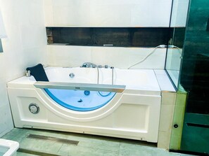 Suite de lujo | Baño | Tina profunda, regadera tipo lluvia, toallas, papel de baño 