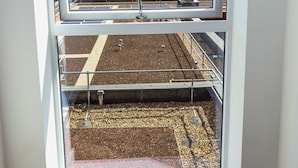 A window with a view of a rooftop garden and buildings in the background. - Captivating 1-bed Apartment in London (London)