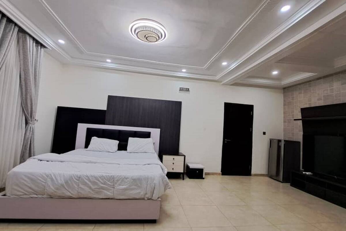 Um quarto moderno com uma cama grande, uma televisão e uma lareira.