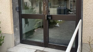 A glass door entrance with a metal handle and a keypad lock. - Charming Apartmemt in Stockholm City (Stockholm)
