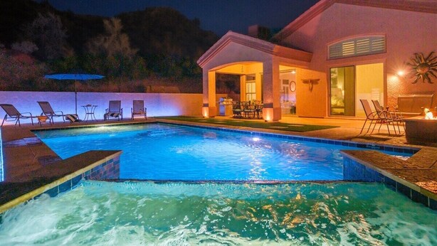 A swimming pool with lounge chairs and a patio area.