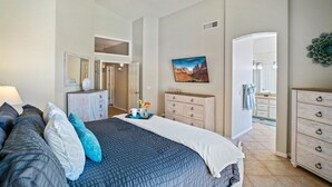 A bedroom with a bed, dresser, and a ceiling fan.