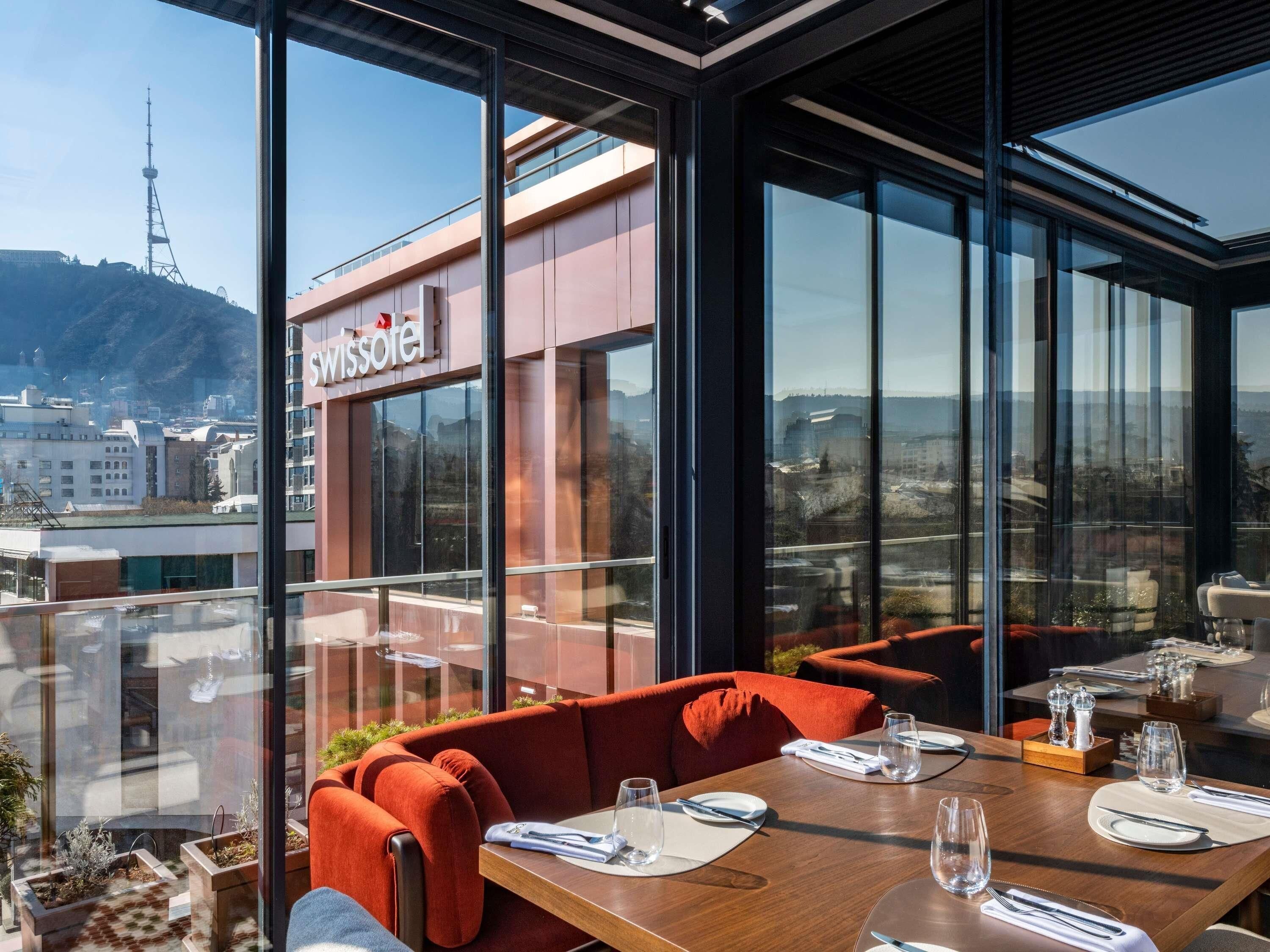 Un restaurant offrant une vue sur la ville et les montagnes.