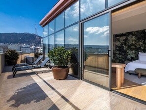 A modern hotel room with a large sliding glass door, a potted plant, a bed, and a small table. - Swissôtel Tbilisi (Tbilisi)