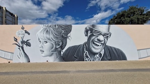 Une fresque représentant une rose et une personne, peinte sur un mur.