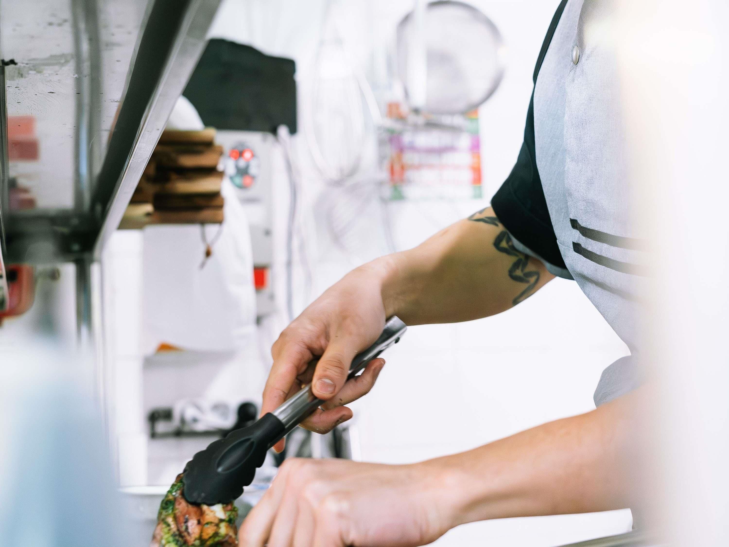A person using a tool on a food item, likely preparing or cooking it.
