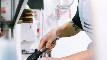 A person using a tool on a food item, likely preparing or cooking it.