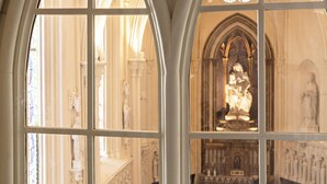 A view through a stained glass window of a church interior with arched ceilings and a central altar. - Domaine de la Reine Margot Paris-Issy - MGallery Collection (Issy-les-Moulineaux)