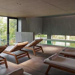 Una piscina techada, sillones reclinables de piscina