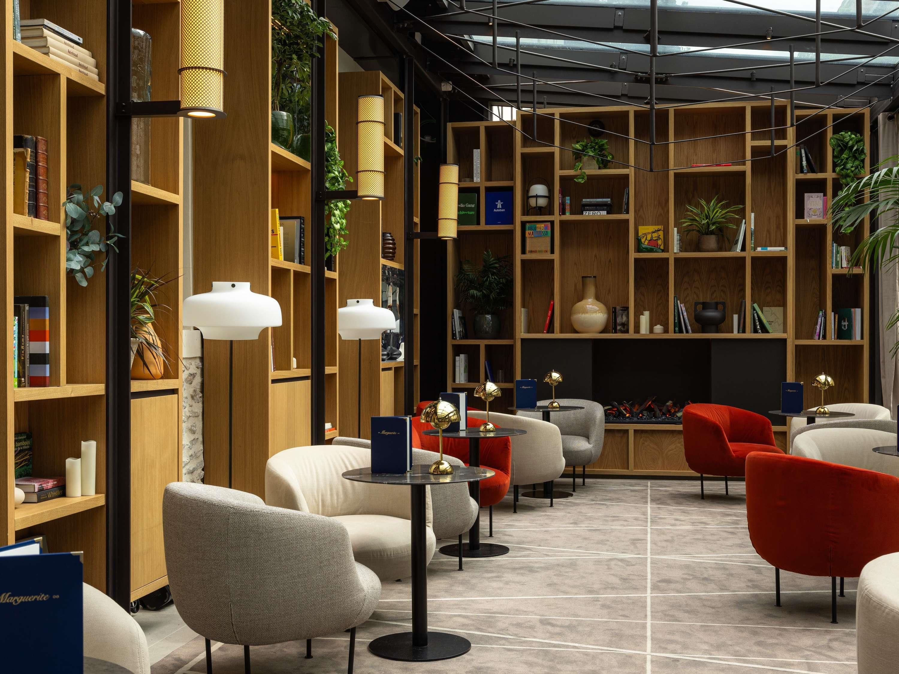 A modern library with bookshelves, reading lamps, and comfortable seating areas.