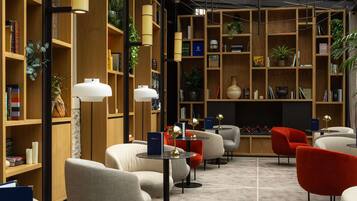 A modern library with bookshelves, reading lamps, and comfortable seating areas.