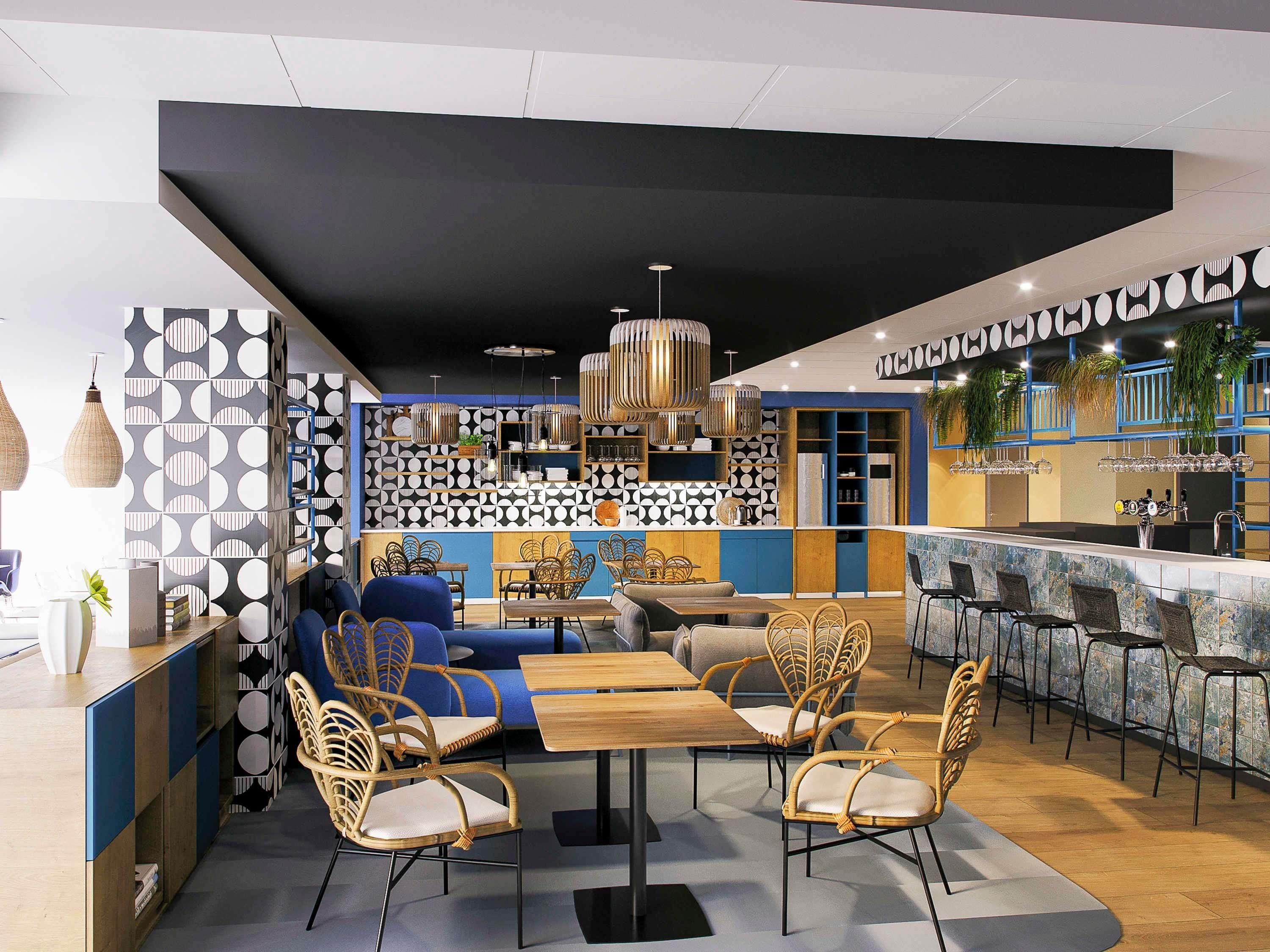 Un interior moderno con una zona de bar, asientos con sillas de mimbre y paredes con diseño.
