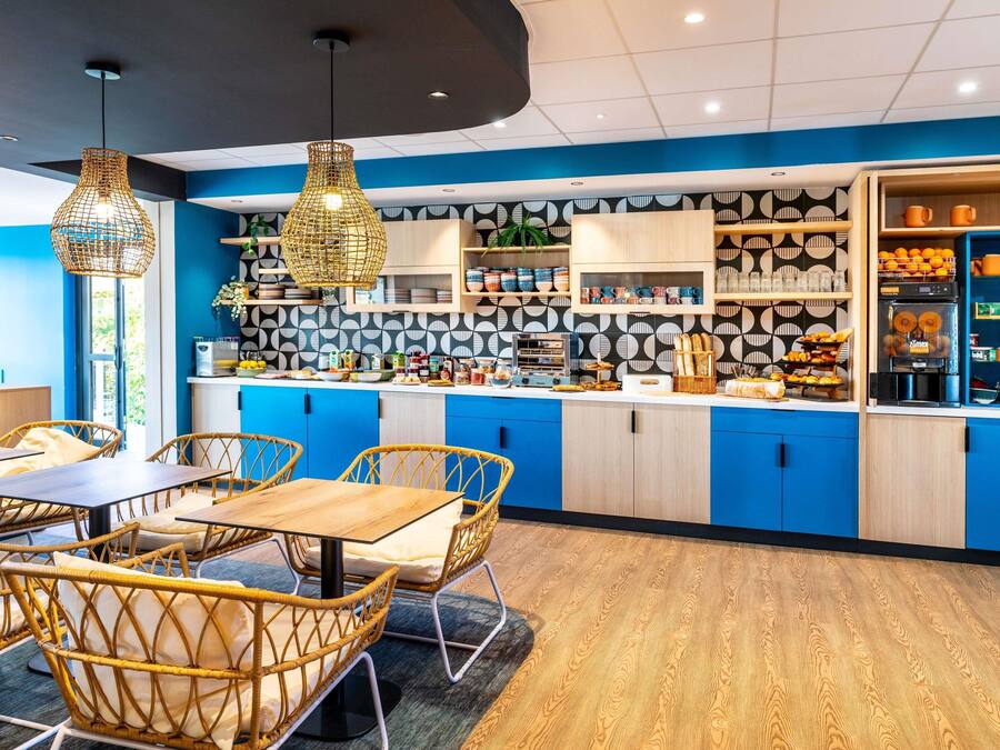 A modern kitchen with blue cabinets, a wooden countertop, and a variety of food items.