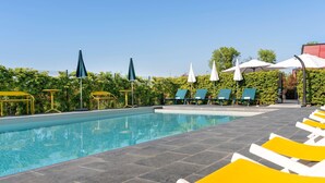 A pool area with lounge chairs and umbrellas. - Ibis Styles Miramas - Provence (Miramas)