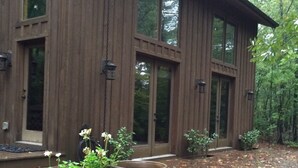 Une maison en bois avec de grandes fenêtres et une véranda.