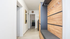 A hallway with a bench, a wooden wall panel, and a mirror. - Apartments Loncar (Vir)