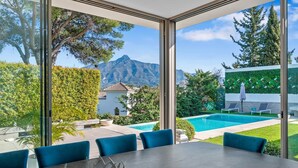 A modern dining area with a view of a swimming pool and mountains. - RDR234 - Amazing modern villa located minutes from beach (Marbella)