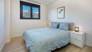 A bedroom with a bed, bedside tables, a window, and a framed artwork on the wall. - RDR274 - NEW 3 bedroom Apt with pool + near beach (Estepona)