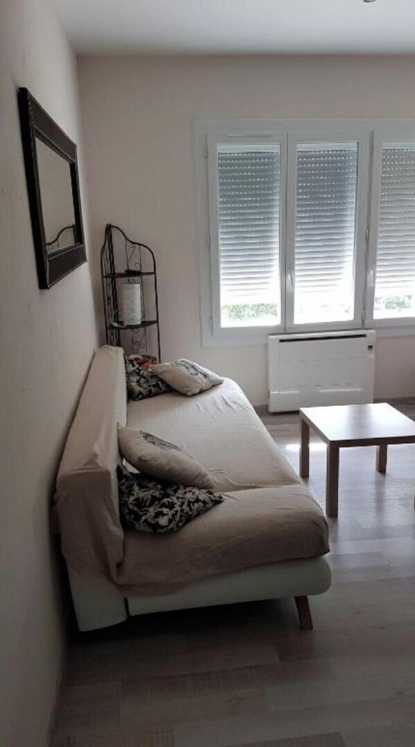 Relax in this inviting living room with a comfortable sofa, side table, and large window offering a view.