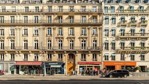 A multi-story building with a classical architectural style, featuring ornate balconies and large windows. - Merveil - Signature Suite - Louvre - Opera I (Paris)