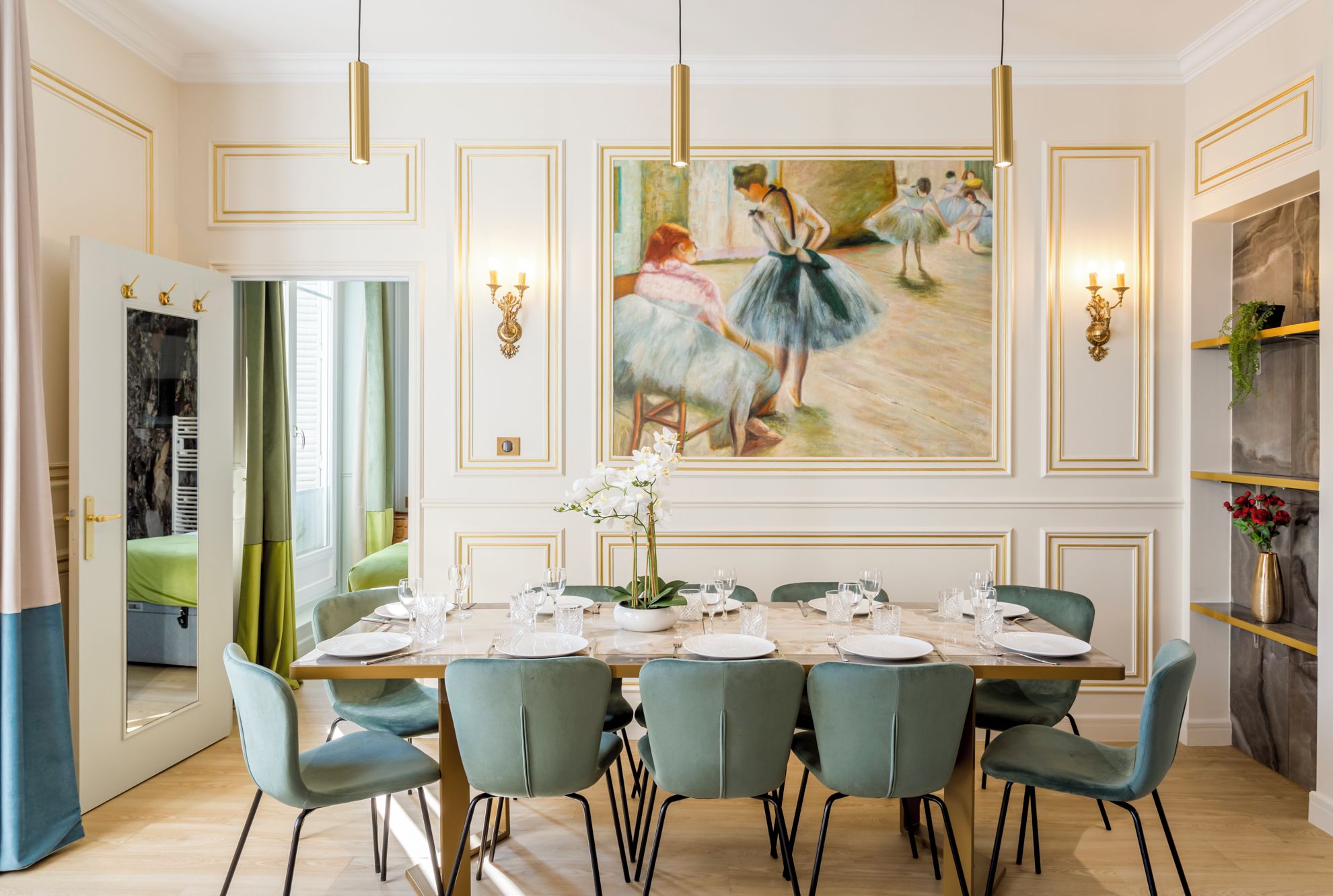 A dining room with a long table set for six, green upholstered chairs, and a large painting of ballerinas on the wall.