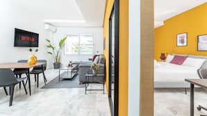 A modern living room with a sofa, coffee table, and TV mounted on the wall. - StayHere Rabat - Agdal Quiet Living (Rabat)
