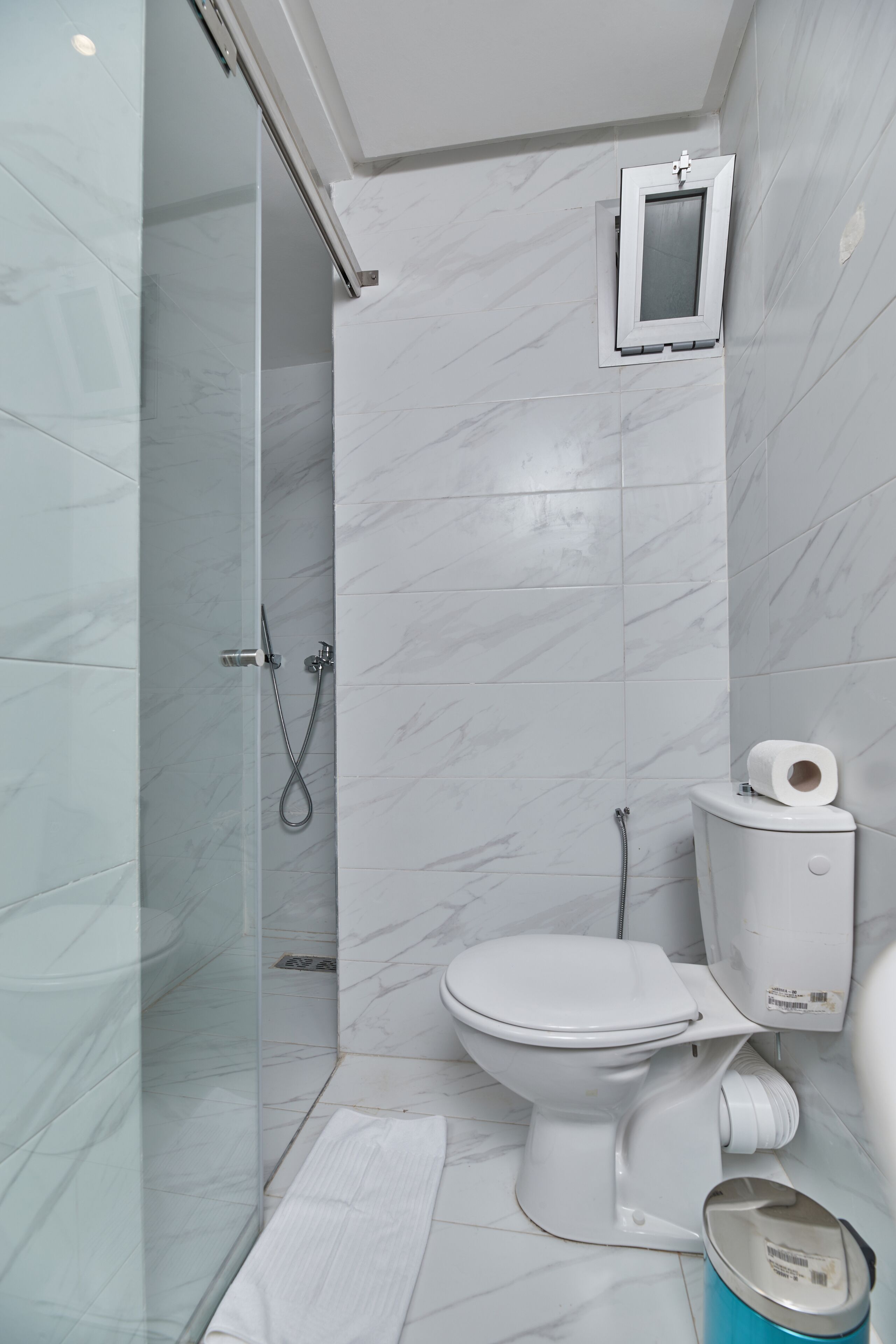 A bathroom with a glass-enclosed shower, a toilet, and a bidet.