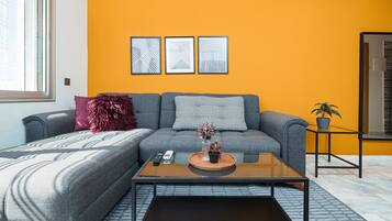 A modern living room with a sofa, a coffee table, and a small side table with a plant.