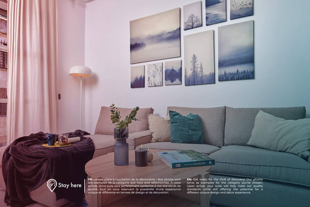 Uma sala de estar moderna com um sofá cinza, uma mesa de centro com um livro, um vaso com plantas e um abajur.