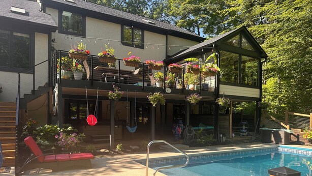 A two-story house with a swimming pool, outdoor seating, and hanging flower baskets. - Close to city, far from ordinary. 
Peace and tranquility await! (Westerville)
