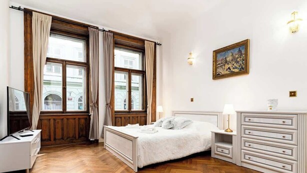 Un dormitorio con cama, cómoda, mesita de noche y un cuadro en la pared.