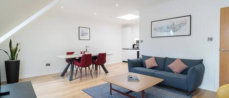 Un salon moderne avec un canapé, une table basse et un coin repas.