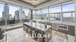Una cocina moderna con ventanas amplias, una isla central y vistas a la ciudad.