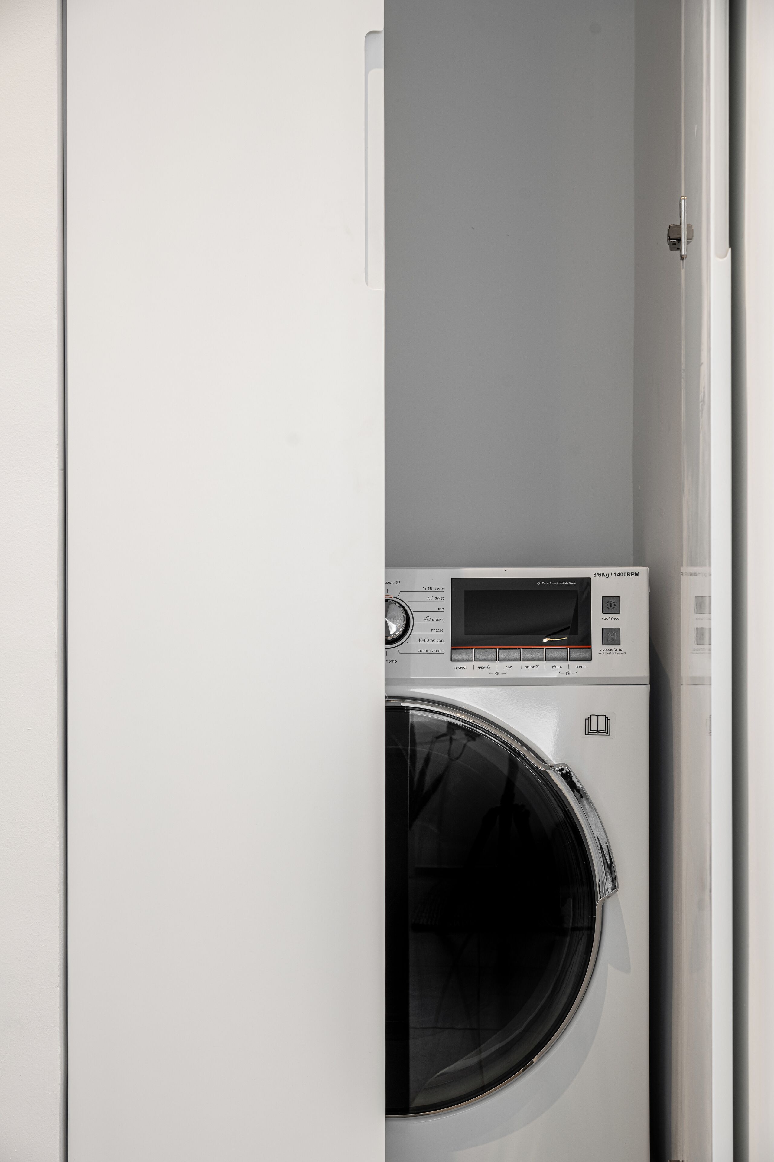 A compact, modern laundry room with a built-in washer and dryer.