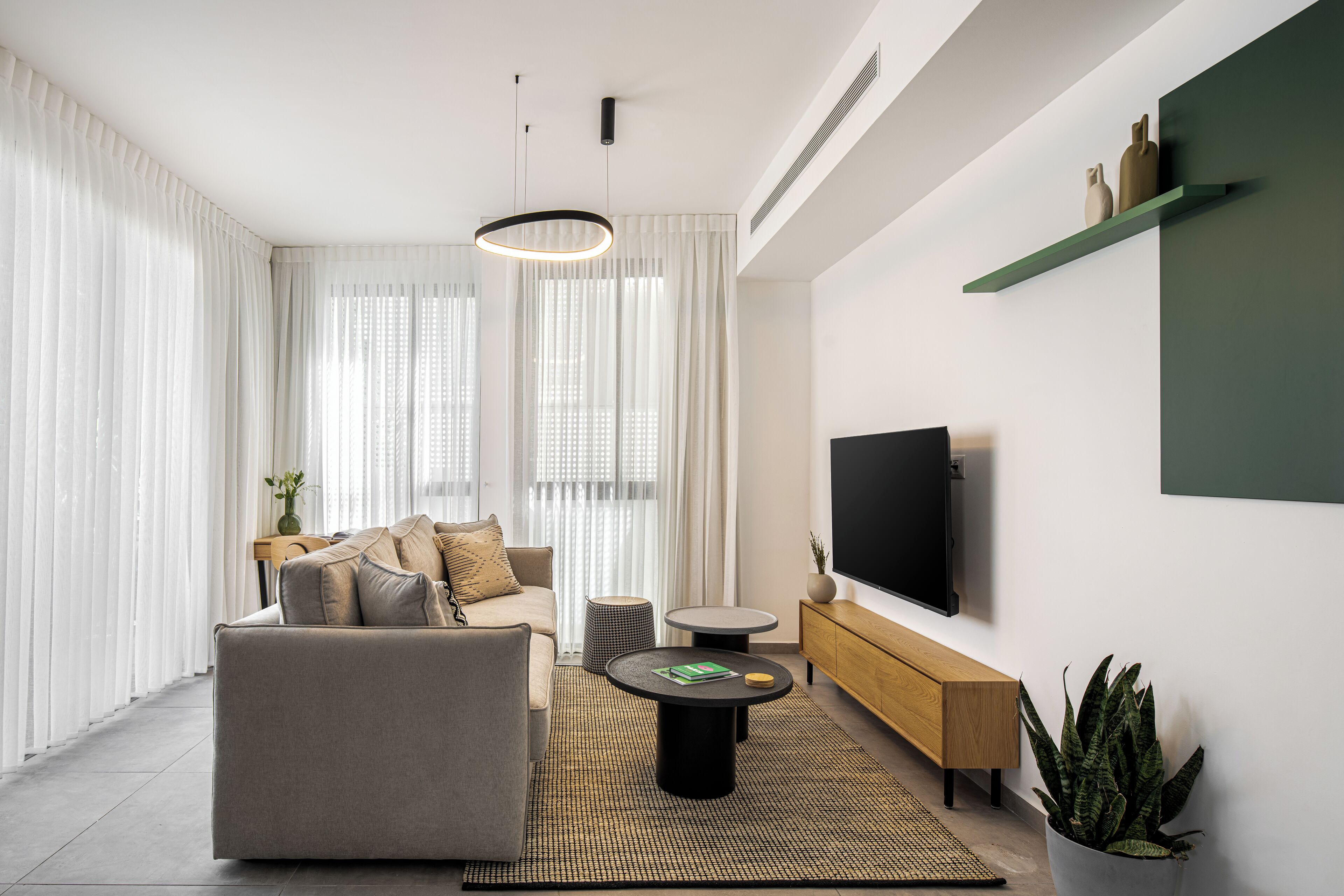 Ein modernes Wohnzimmer mit Sofa, Couchtisch und Fernseher.