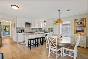 Enjoy cooking and dining in this well-equipped kitchen with a central island, microwave, coffee maker, and sink.