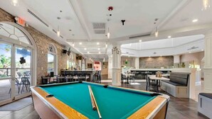 A pool table in a modern indoor space with a bar and seating area. - Spacious & Modern 3BR Townhouse Near Disney w/ Pool & Lazy River! (Davenport)