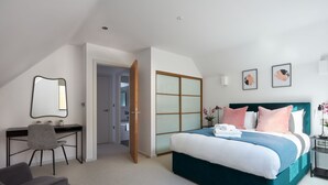 A modern hotel room with a large bed, a desk, and a wardrobe. - Hammersmith Mews by Viridian Apartments (London)