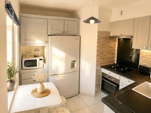 A modern kitchen with a refrigerator, microwave, stove, and oven.