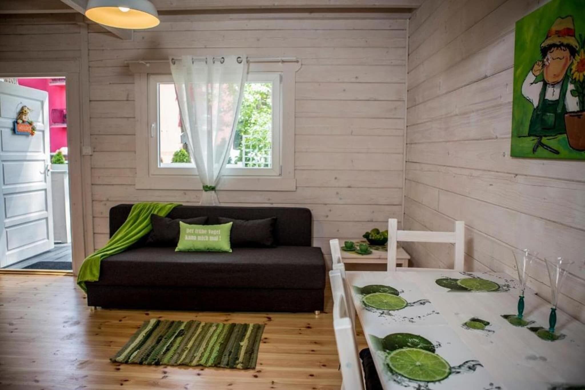 Ein gemütliches Zimmer mit einem dunklen Sofa, einem kleinen Tisch mit Limettenscheiben und einem Bild an der Wand.