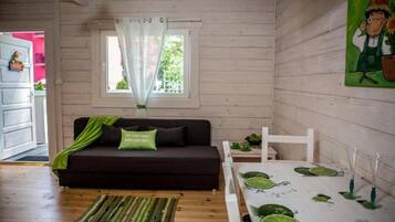 Ein gemütliches Zimmer mit einem dunklen Sofa, einem kleinen Tisch mit Limettenscheiben und einem Bild an der Wand.